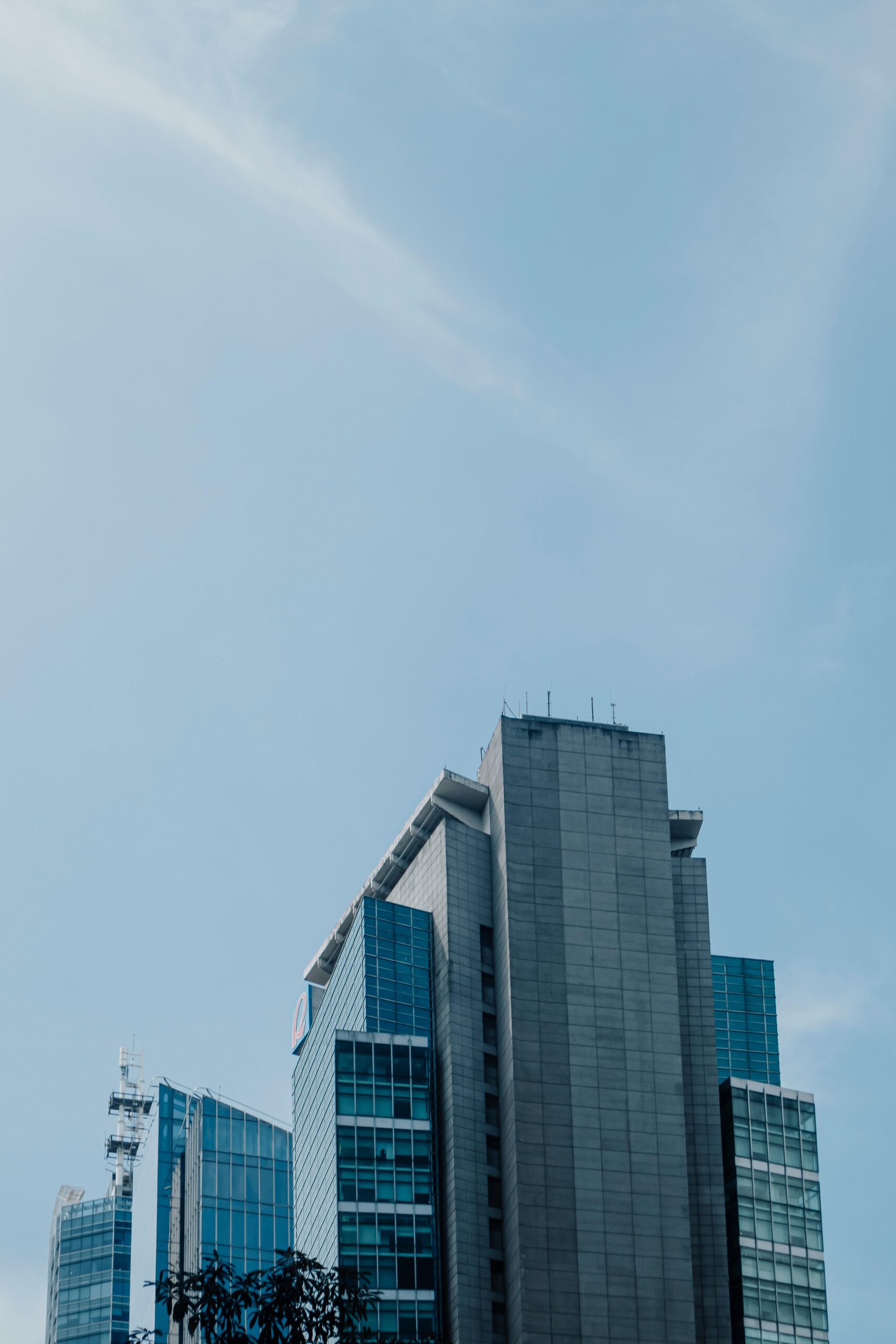 Modern skyscraper with a clear blue sky backdrop showcasing urban architecture.