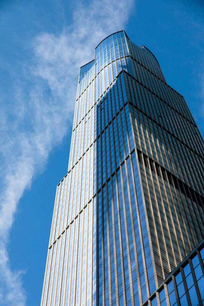 A stunning view of a modern glass skyscraper against a clear blue sky in New York City.