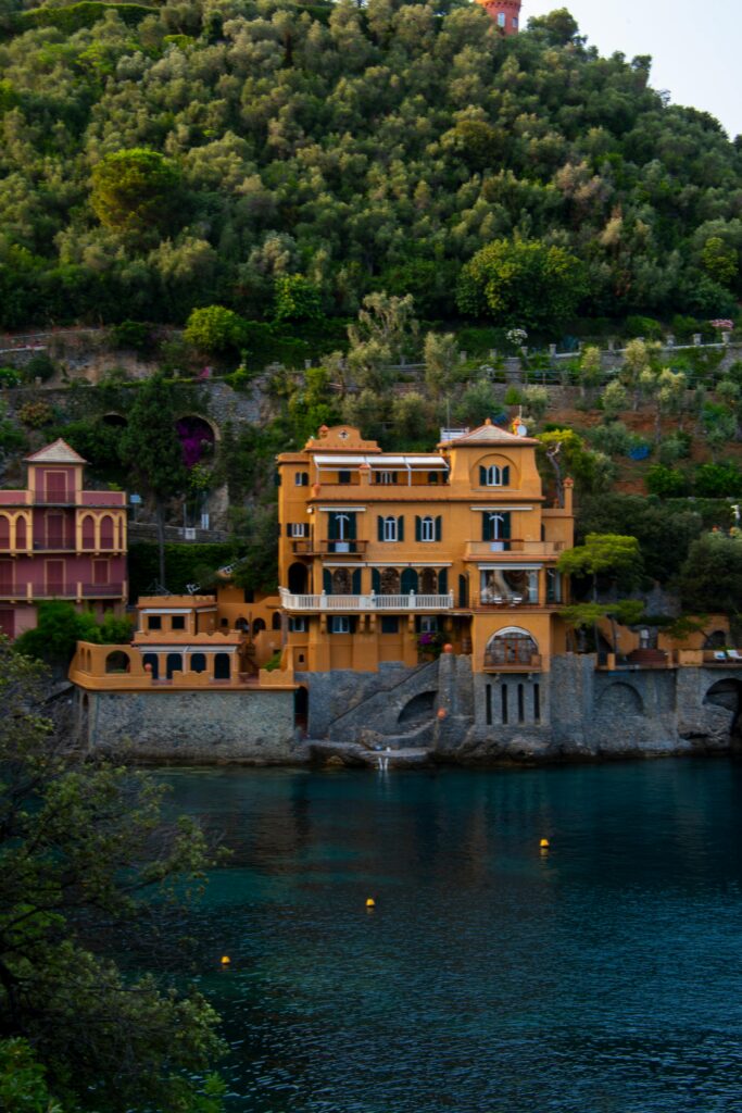 Elegant villa overlooking the waterfront in Portofino, Italy, surrounded by lush greenery.